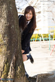 Student standing behind tree wearing uniform