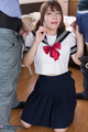 Kneeling between two men in seifuku uniform holding cocks