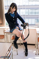 Momoki nozomi sitting on desk wearing uniform holding camera knee raised