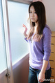 Standing by window long hair purple sweater wearing jeans.jpg