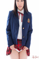 Student in uniform raising hem of plaid skirt exposing her panties