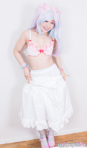Minano Ai lying on her back wearing bra giving handjob